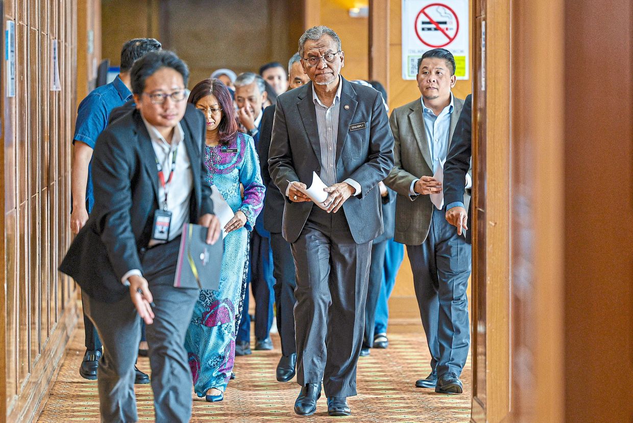Meet the press: Dr Dzulkefly (centre) walking towards the press conference where he presented the findings of the three-month probe. — Bernama