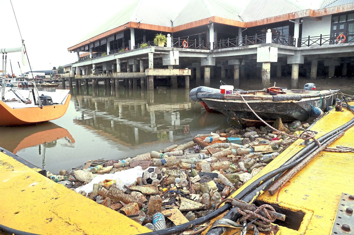 Plastic waste washing up along the marina of the Royal Selangor Yacht Club during low tide.