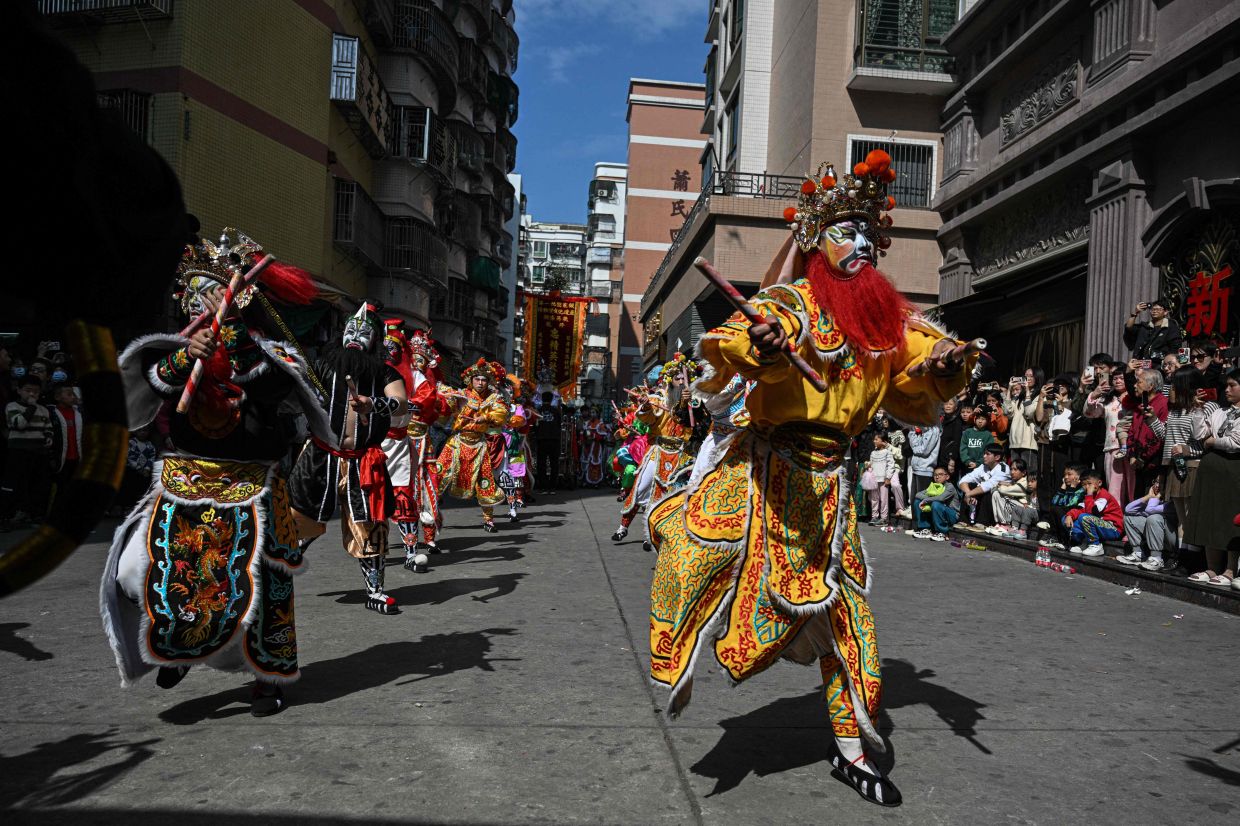 Dancers in costumes perform a traditional Yingge dance outside an ancestral temple in Shantou, in southern China's Guangdong province on Jan 23. Photo: AFP 