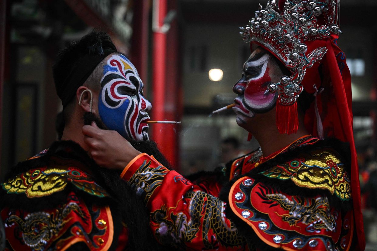 Yingge dancers prepare at an ancestral temple ahead of a traditional folk Yingge dance performance in Shantou, in southern China's Guangdong province. Photo: AFP 