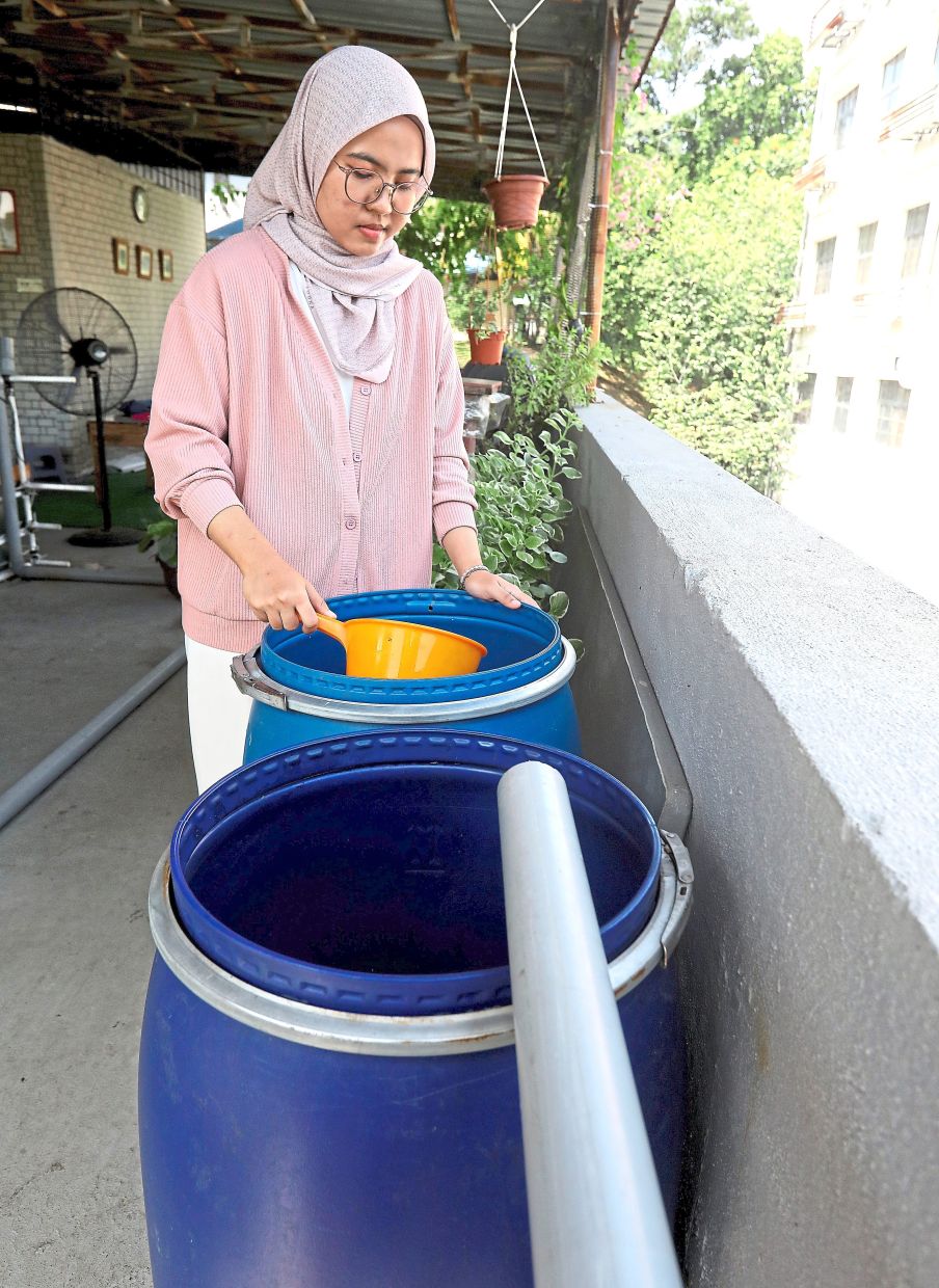 Siti Nurmaisara showing the rainwater harvesting system.