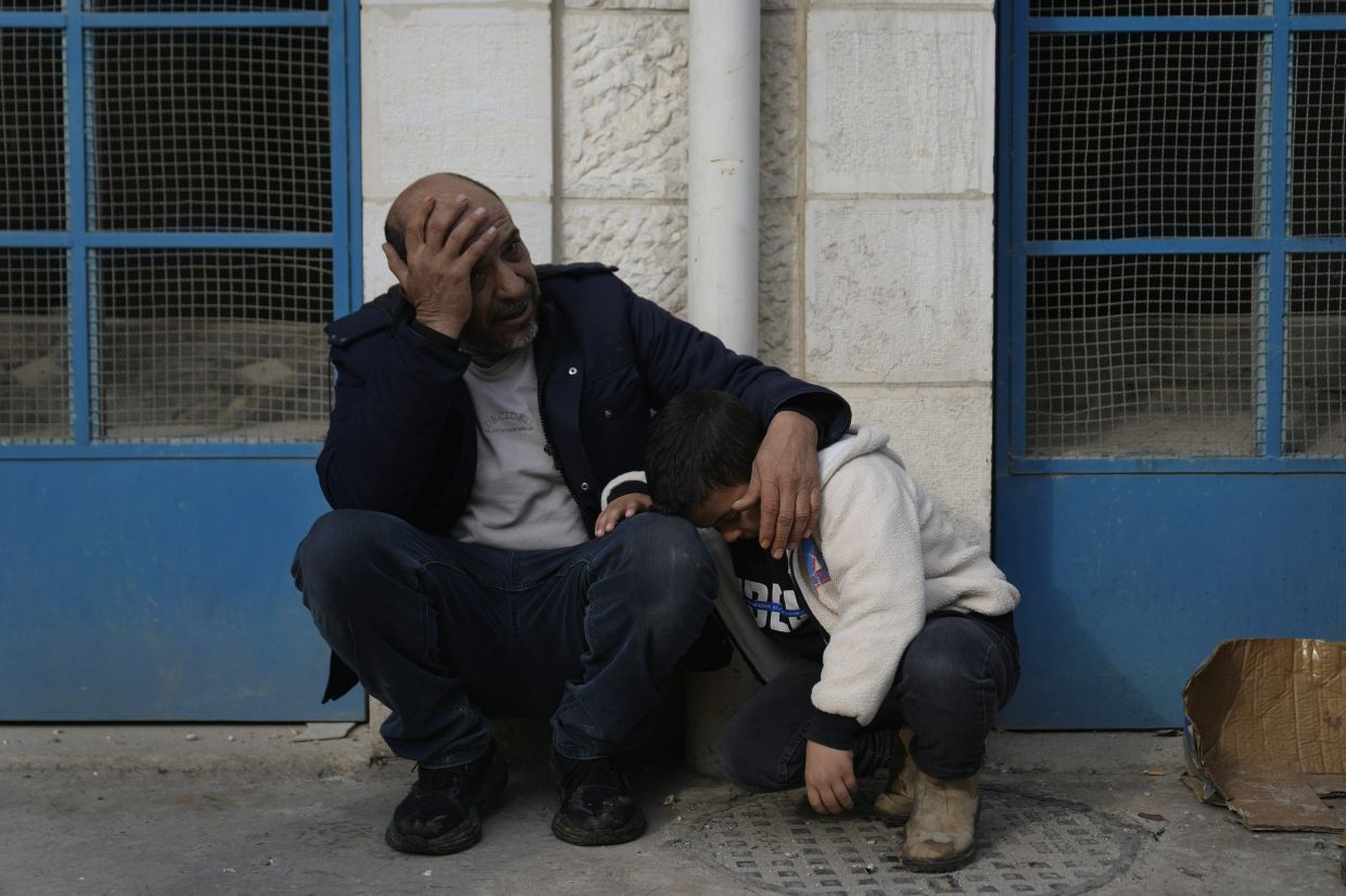 Palestinian mourners wait outside the morgue for their bodies of their relatives  killed during an Israeli airstrike in the West Bank refugee camp of Jenin on Jan 16, 2025. — AP
