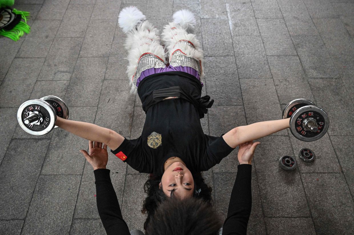 Lion dancer Lin Xinmeng doing strength training in a practice session at an ancestral temple in Shantou in southern China's Guangdong province. Photo: AFP 