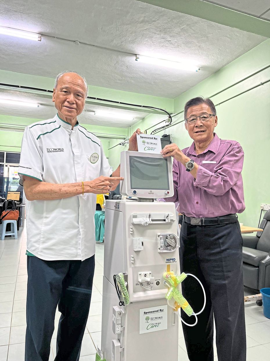Lee (left) handing over the machine to Yeo.