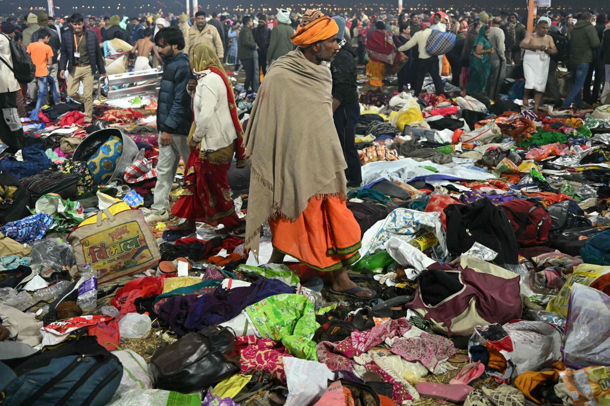 Pilgrims look for their belongings at the site of a stampede amid the ongoing Maha Kumbh Mela festival in Prayagraj on Jan 29.A pre-dawn stampede at the world's largest religious gathering killed at least 30 people in India on January 29, with many more injured after a surging crowd spilled out of a police cordon and trampled bystanders. — AFP