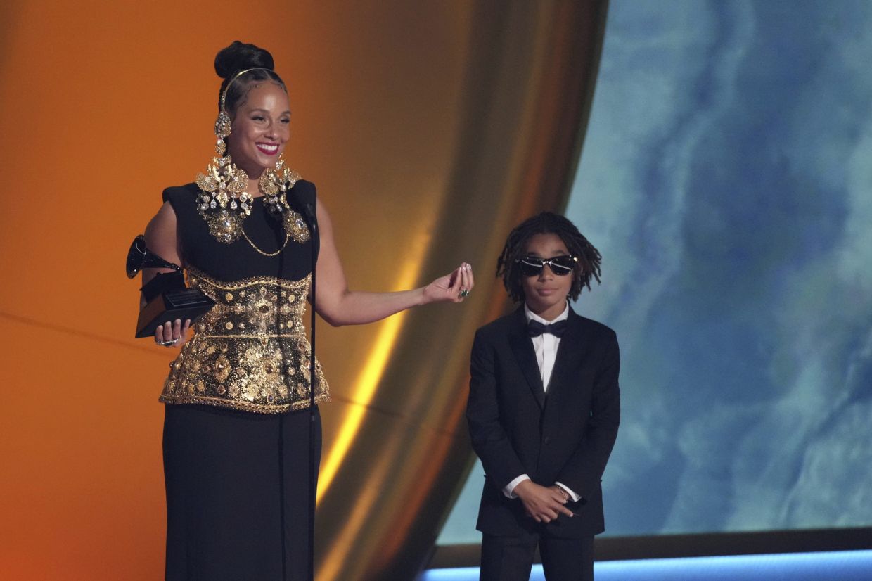 Alicia Keys accepts the Dr. Dre Global Impact Award during the 67th annual Grammy Awards. Her son, Genesis Ali Dean looks on from right. Photo: AP