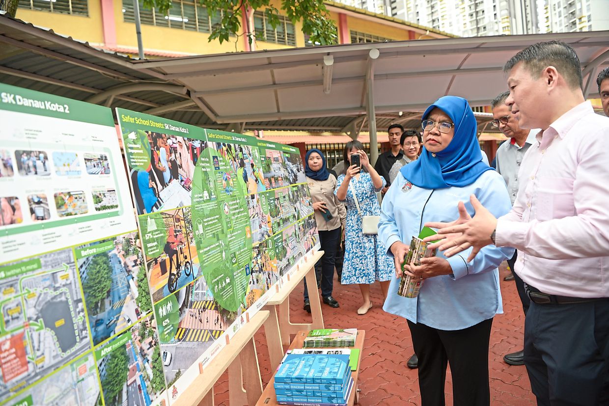 Lua (right) explaining the road design to Maimunah during the launch of the pilot project at SK Danau Kota 2.