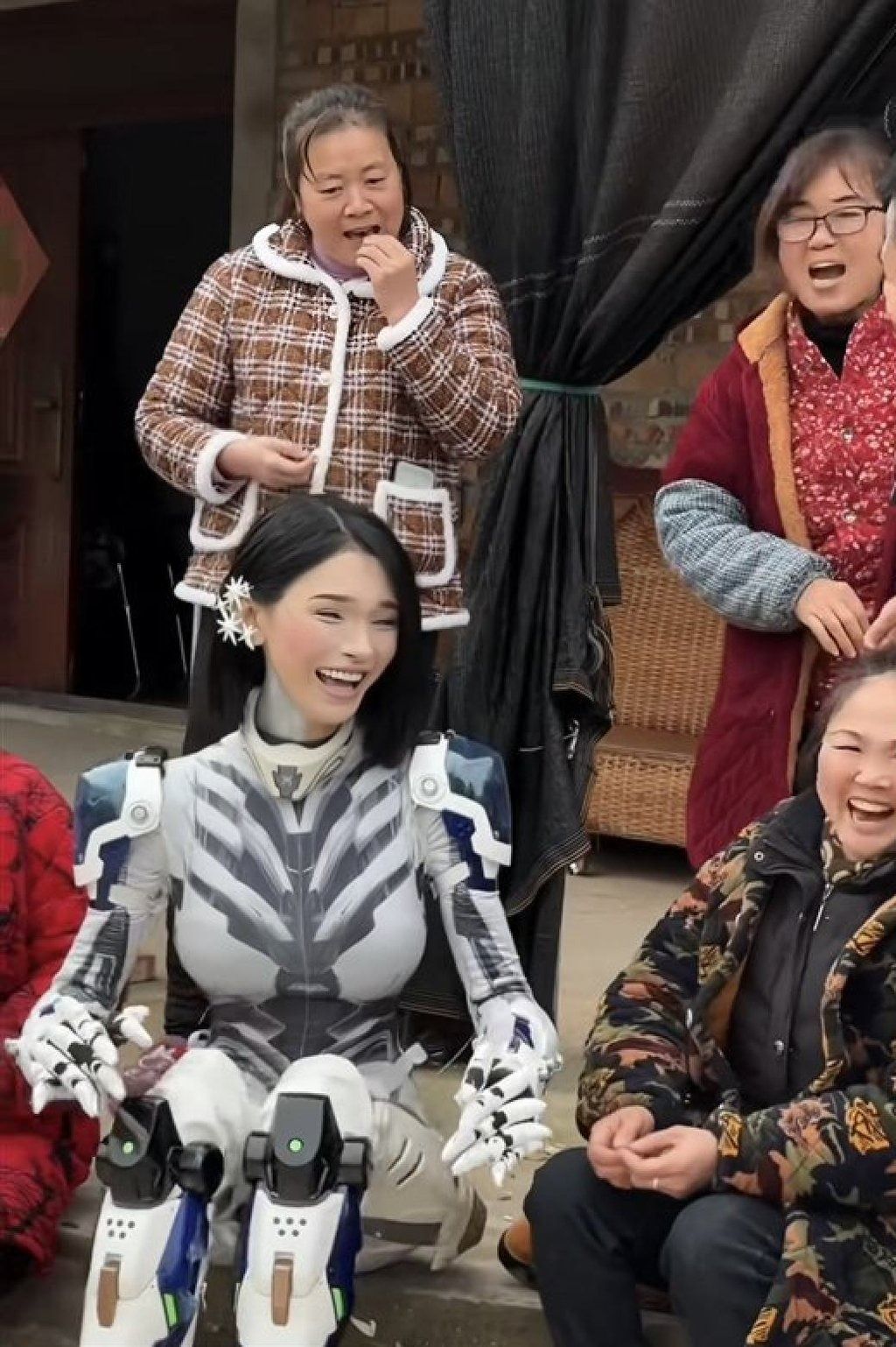 Looking slightly more human, the “robot” laughs and jokes with villagers. - Douyin