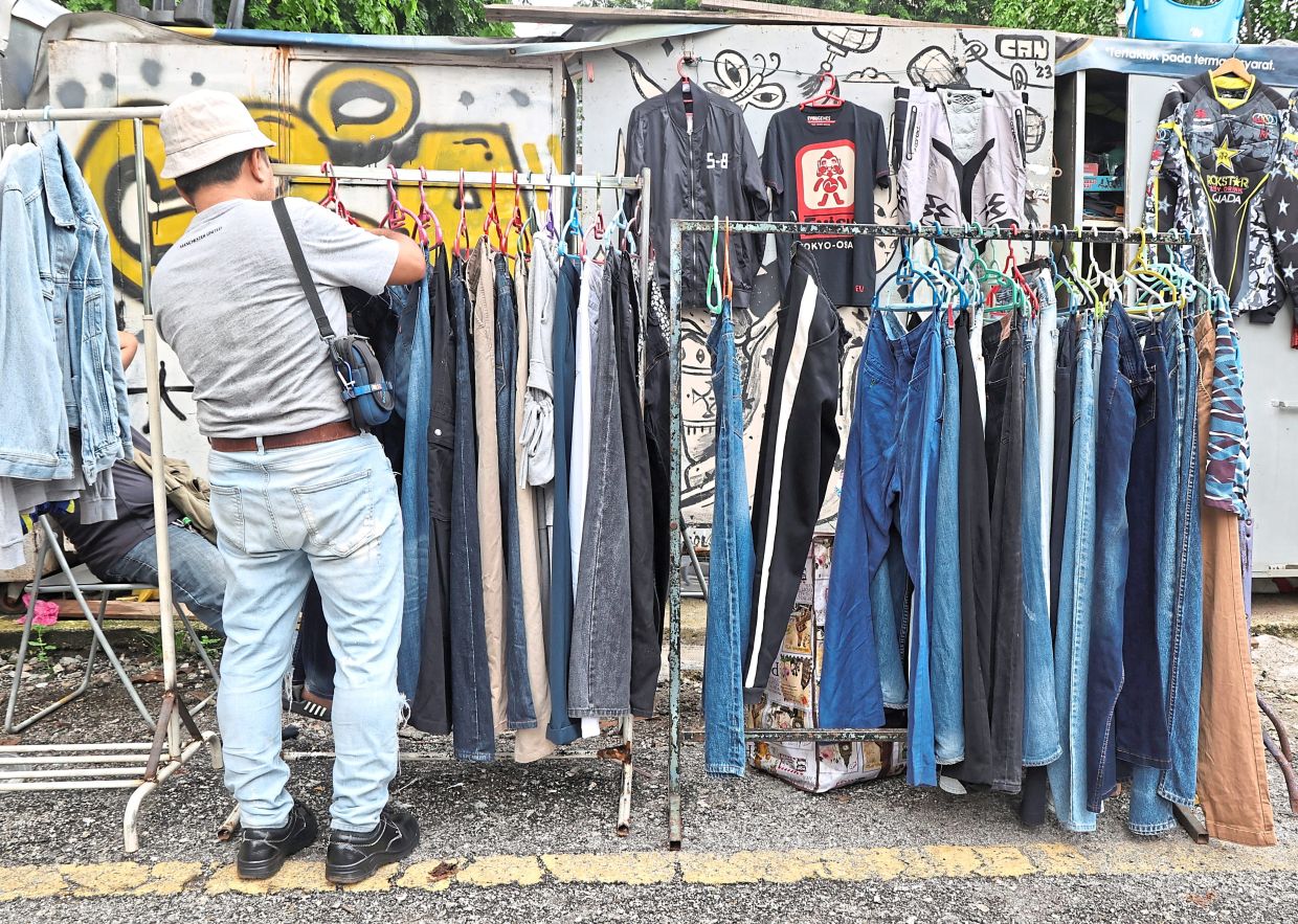 A man in the market looking for jeans.