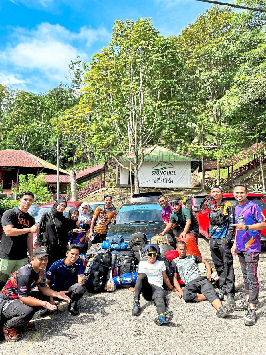 Excited hikers gathering at the entrance of Gunung Stong State Park, ready to begin their climb above the clouds.(Left) 