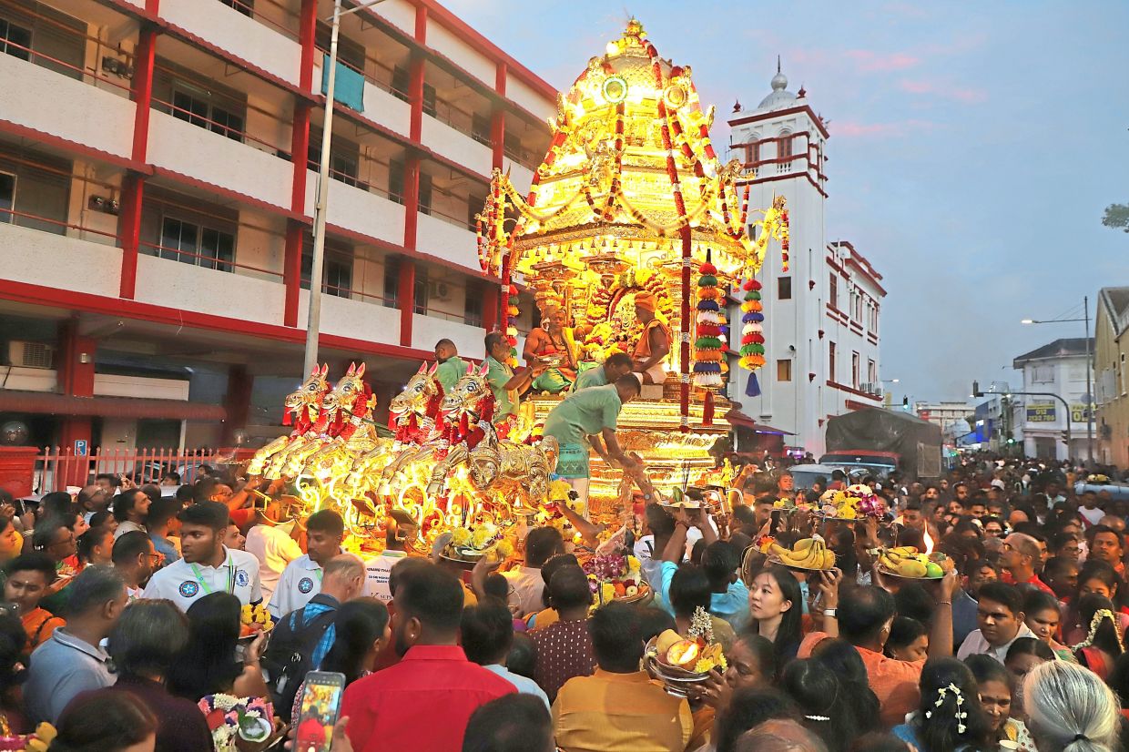 The golden chariot passing by Chulia Street Ghaut during the Thaipusam procession yesterday.