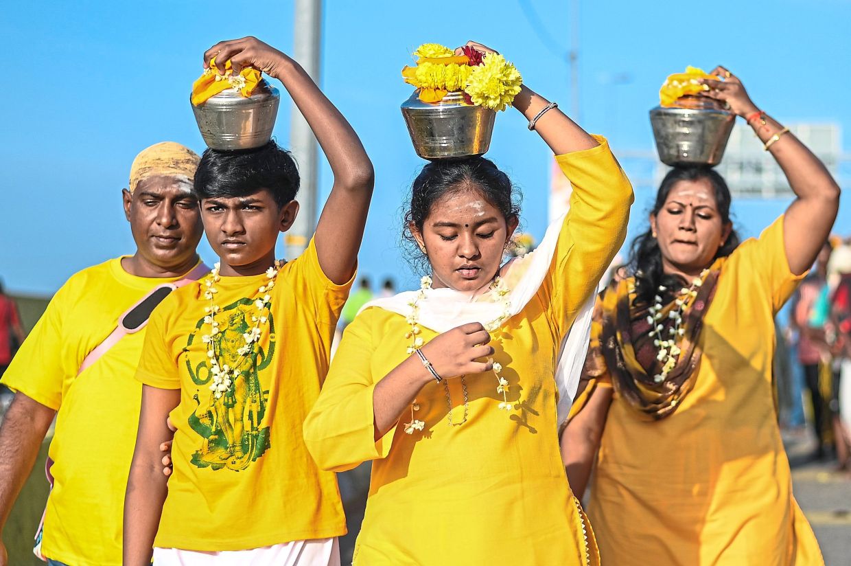 One intention: A family walking together during the Thaipusam celebration at Sri Subramaniar Swamy Temple, Batu Caves.