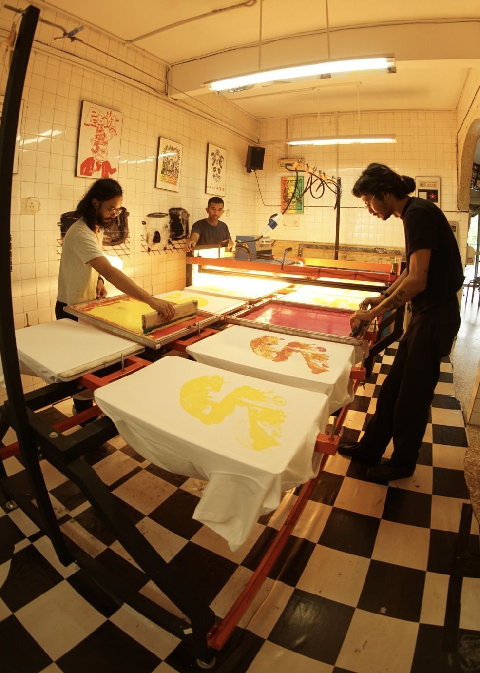 Screen printers and artists (from left) Akid, Fauzan Fuad and Sanan Anuar screen printing in their studio, Bogus Merchandise. Photo: Handout
