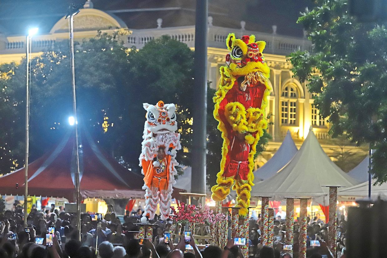 ‘Lions’ dancing on stilts wow the crowd at the Chap Goh Meh celebration.