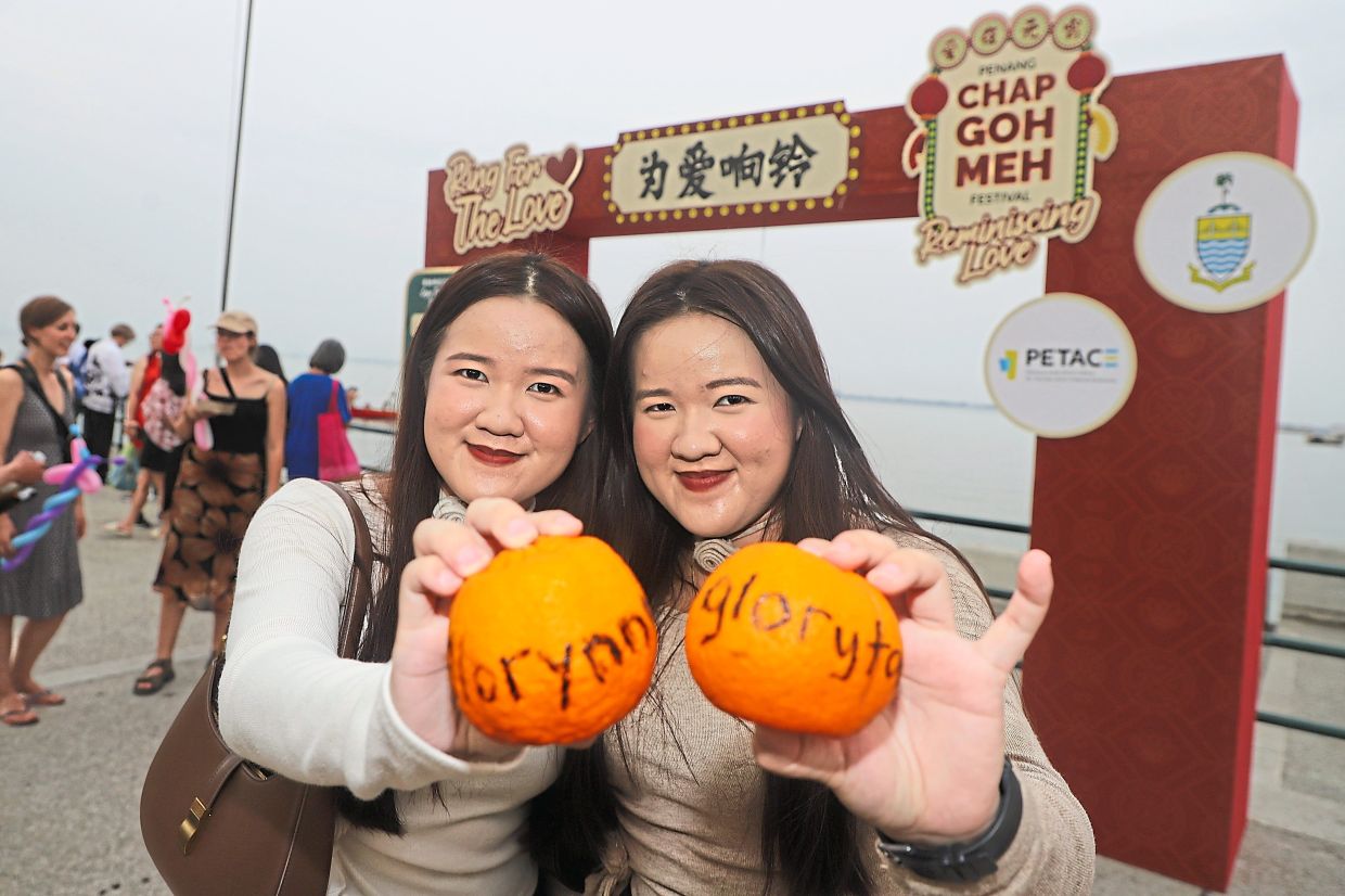 Gloryn (left) and Glory Tay, both 23, with their mandarin oranges at the event.