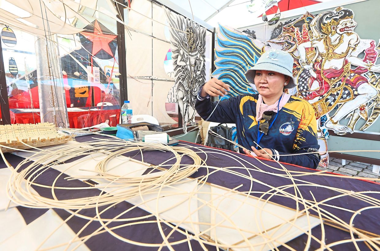 Ni Wayan showcasing her intricately crafted bamboo kites that are inspired by Balinese culture.