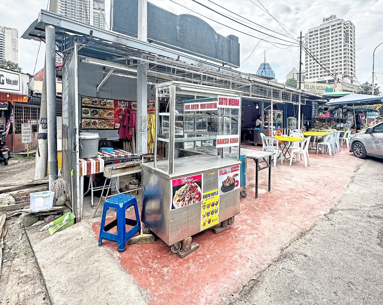 Some busineses in Kampung Baru have illegally extended their shops over drains, making it difficult for Alam Flora workers to clean the drains.