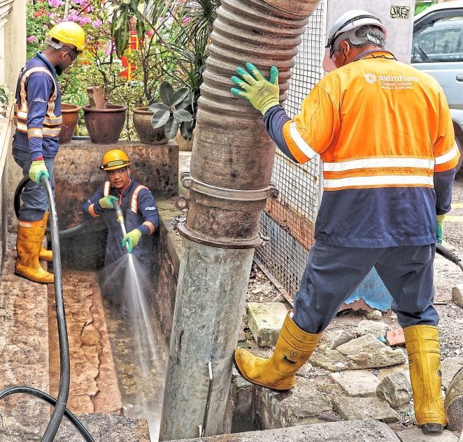Blockage busters: Alam Flora workers using a vacuum truck and water jet to clewar a badly clogged drain in Kampung Baru, Kuala Lumpur. - MUHAMAD SHAHRIL ROSLI/The Star