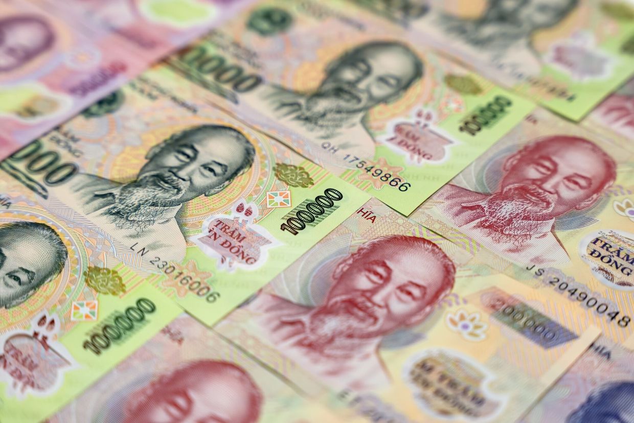 Vietnamese 100,000 dong and 200,000 dong banknotes arranged inside a Vietnam Prosperity Joint Stock Commercial Bank (VPBank) branch in Ho Chi Minh City, Vietnam. Vietnam's parliament raised the economic growth target to at least 8% for 2025, setting the stage for Asia's growth star to achieve another stellar year even as the threat of US tariffs looms. -- Photographer: Maika Elan/Bloomberg