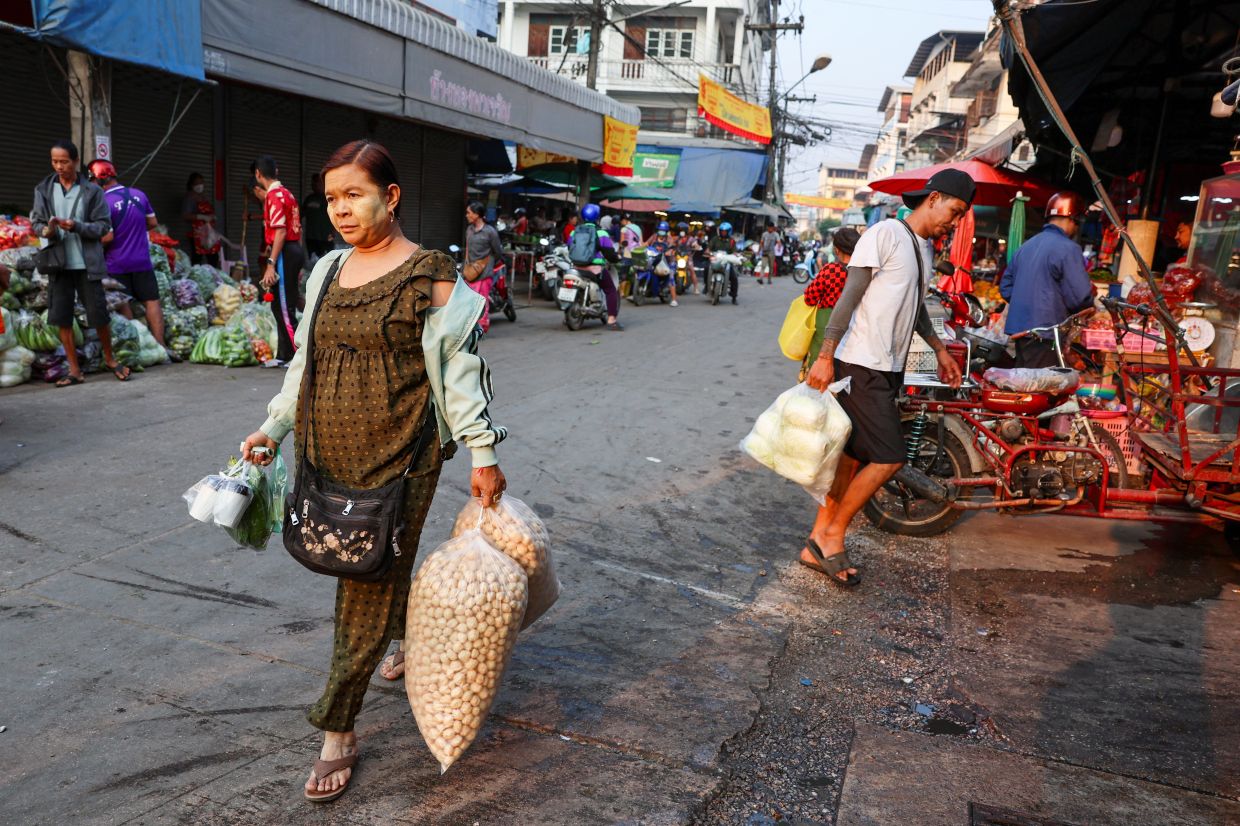 A migrant worker from Myanmar with thanaka paste on her face walks while shopping at a local market, in Mae Sot District, Tak province, Thailand on Friday, February 21, 2025. -- REUTERS/Chalinee Thirasupa