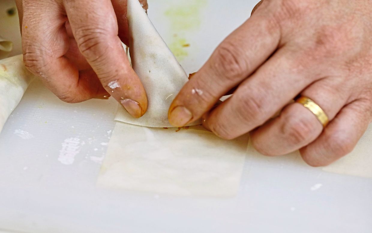 Place one tablespoon of filling onto one end of the wrapper, make a triangular fold and continue to wrap in a triangular shape.