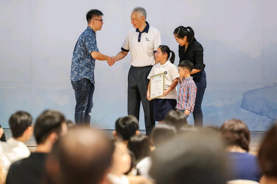 Senior Minister Lee Hsien Loong congratulating families during an education award ceremony at Townsville Primary School on Feb 22. - Photo: ST