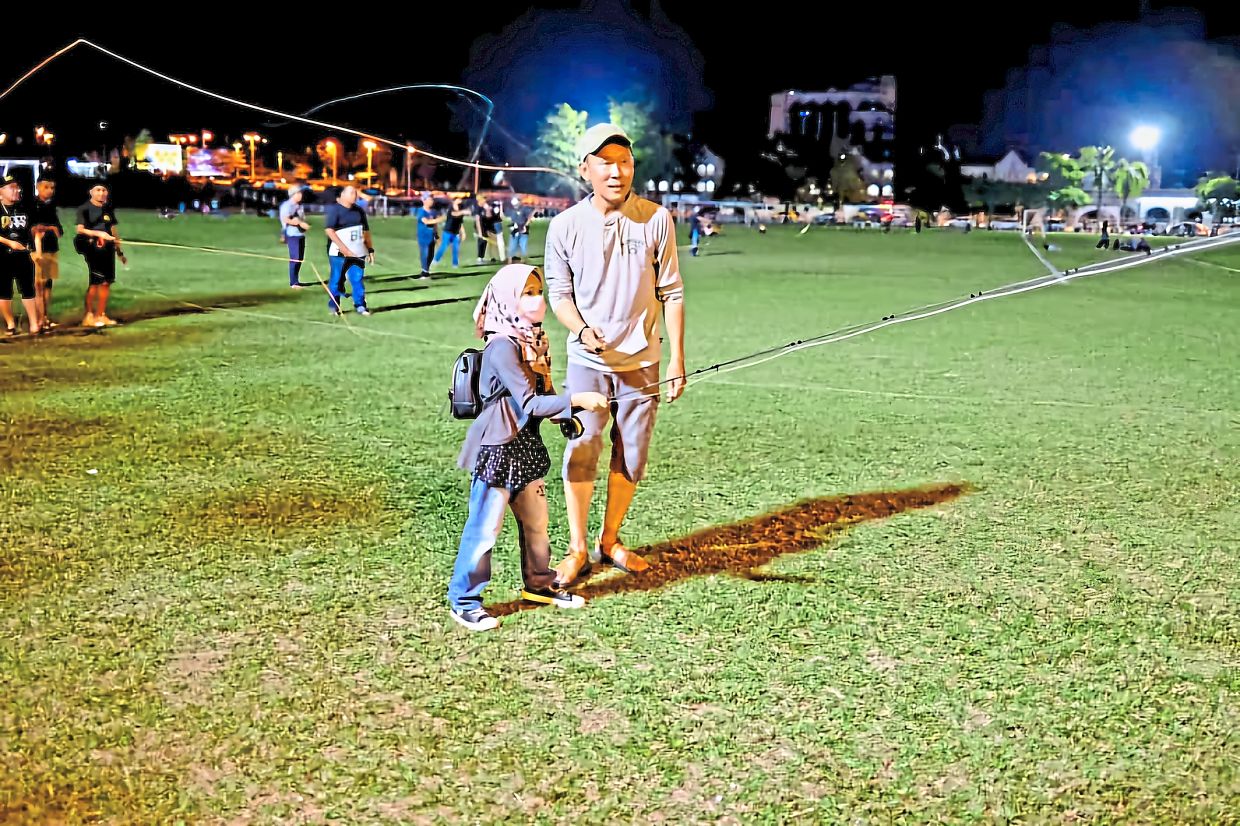 Foo teaching a girl how to handle a fly rod. 