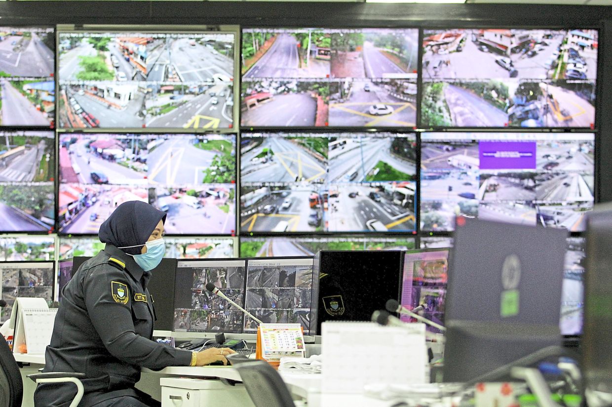 Footage being monitored at MBPP’s CCTV control room in Komtar. — FilepicLeft: A CCTV camera installed at the Octopus Bridge in George Town, Penang. — ZHAFARAN NASIB/The Star