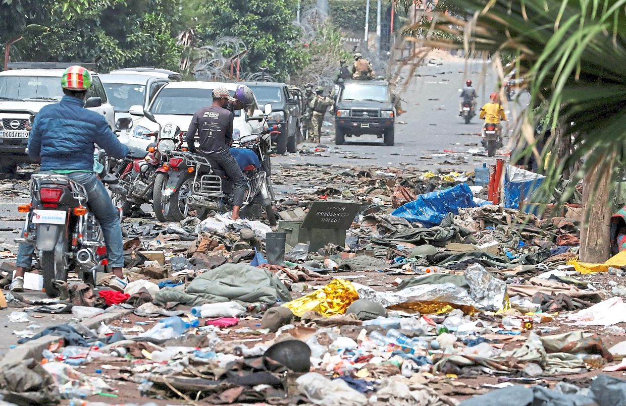 Motorcycle taxi operators looking at military uniforms and ammunition left behind by the DRC armed forces. — Reuters 