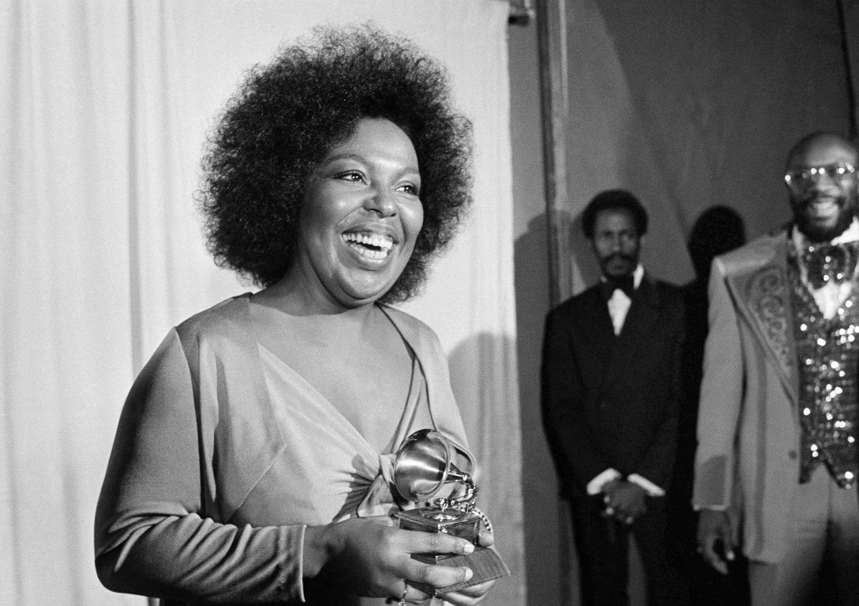 Roberta Flack holds the Grammy award for her record, 'Killing Me Softly With His Song' as singer Isaac Hayes, right, looks on at the Grammy Awards in Los Angeles on March 4, 1974. — Photo: AP/Harold Filan, File