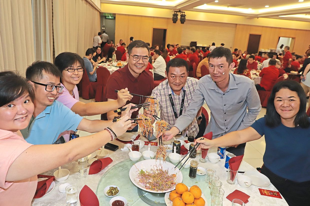 Members of local media tossing ‘yee sang’ in hopes of ushering in a prosperous year. 