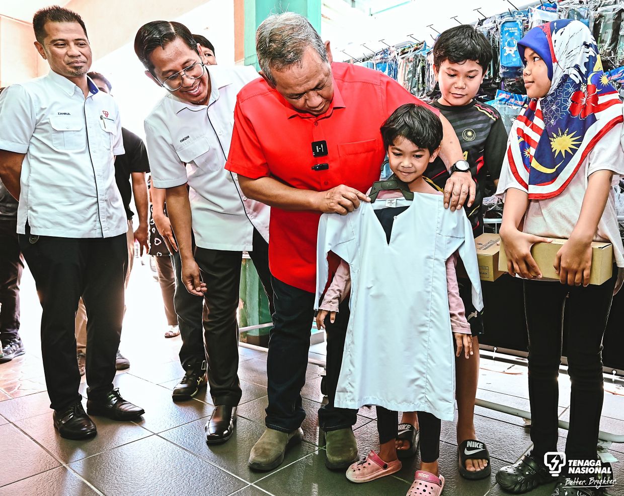 Mentri Besar Datuk Seri Aminuddin Harun (in red shirt) helping out a student at the Ceria Ke Sekolah (CKS) programme in Port Dickson earlier this month.