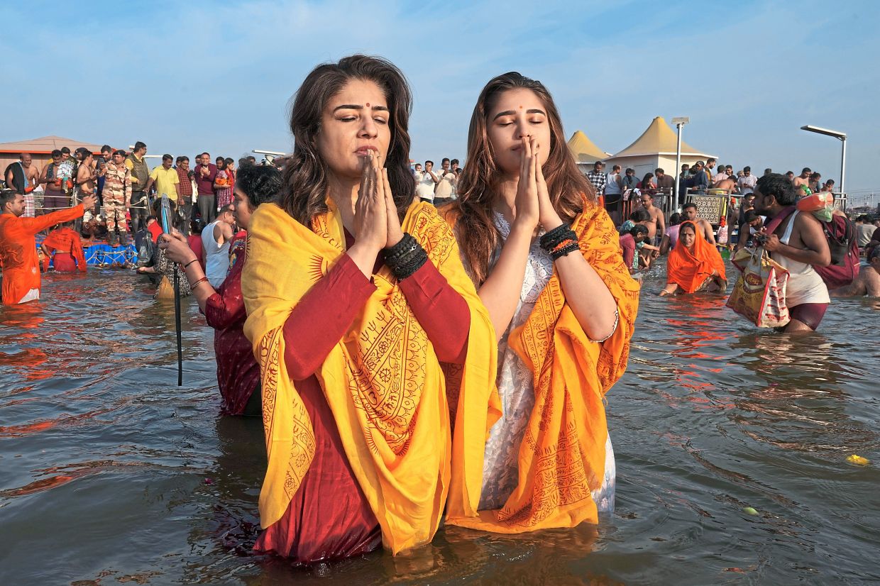 Bollywood actress Raveena Tandon (left) and her daughter Rasha Thadani praying after taking dips. — AFP/AP