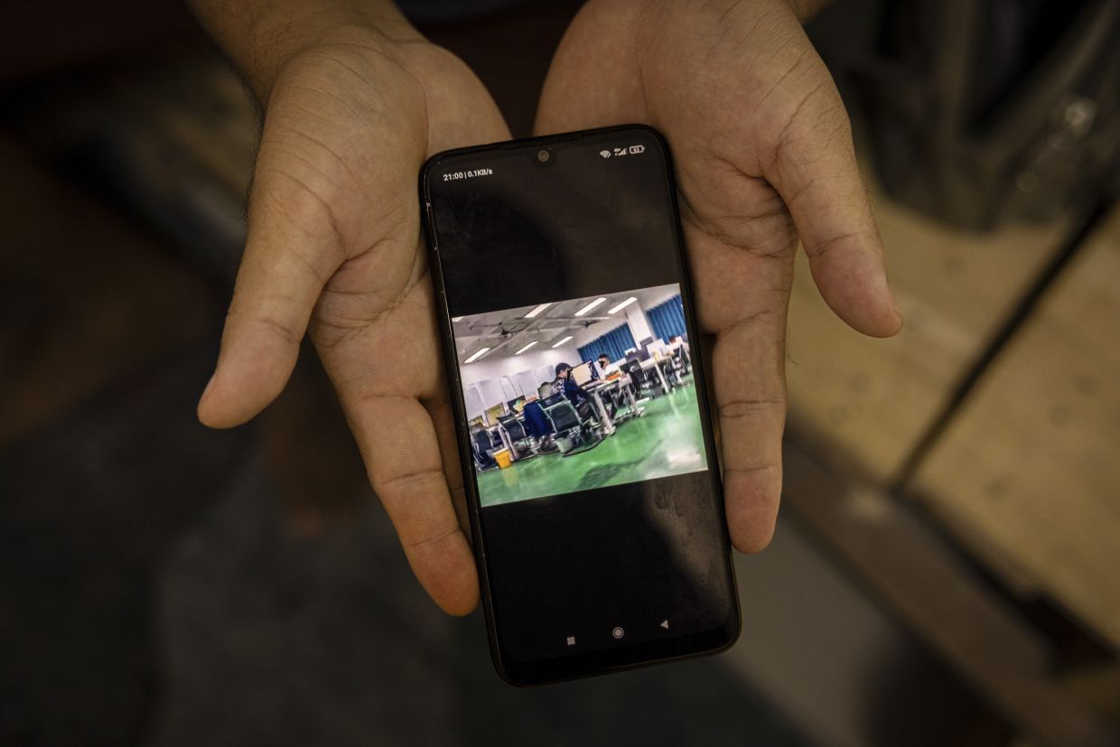 Ko Min, who used to patrol a notorious scam center on the border in Myanmar, displays a photo of the inside of a scam center; in Mae Sot, Thailand, Feb 21, 2025.