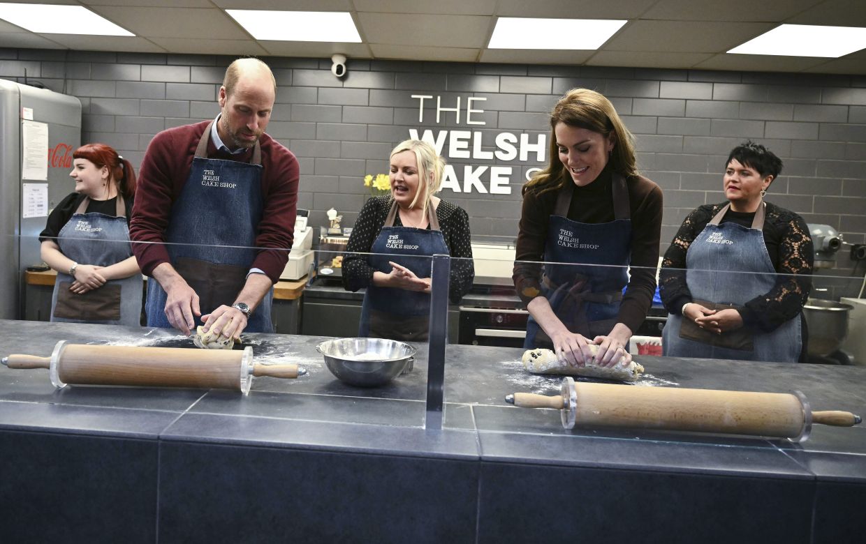 Britain's Prince William and Kate, Princess of Wales make Welsh Cakes, watched by Theresa Connor, owner of the The Welsh Cake Shop, during a visit to Pontypridd Market, south Wales, on Feb 26, 2025. Photo: AP