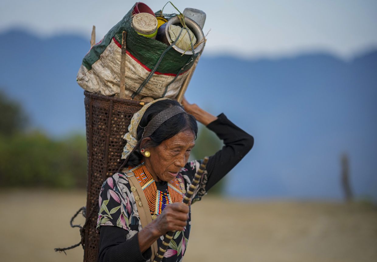 An elderly Kenyan Naga carries a basket filled with her belongings in the India-border village of Longwa, in the northeastern Indian state of Nagaland, Thursday, Dec.12, 2024. -- AP Photo/Anupam Nath