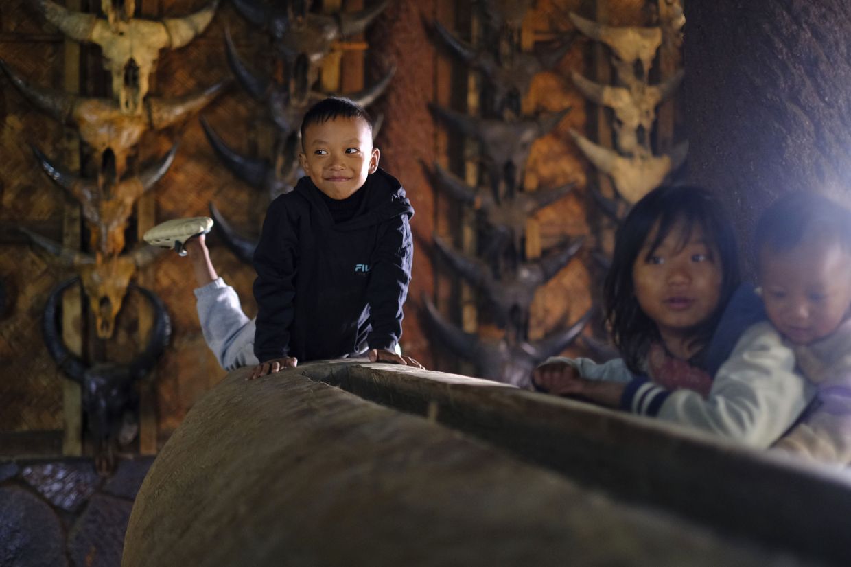Children play by a traditional log drum in the house of the Angh, or chief, at Longwa village on the India-Myanmar border in the northeastern India state of Nagaland, Thursday, Dec.12, 2024. -- AP Photo/Yirmiyan Arthur