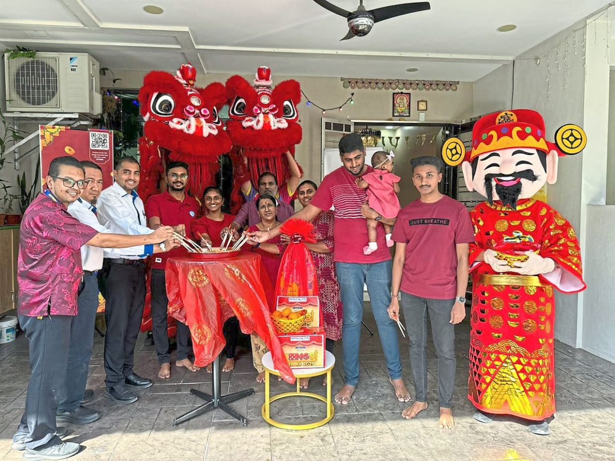 Competition winner A. Surren (right) and his family, together with (from left) Mydin mall manager Amir Affendy Abu Bakar, Mydin branch manager Tunku Mahmud Azhan Tunku Mohd Kamal and Mydin northern region executive director Azmin Saduruddin participating in the yee sang tossing in Gelugor, Penang on Jan 29.