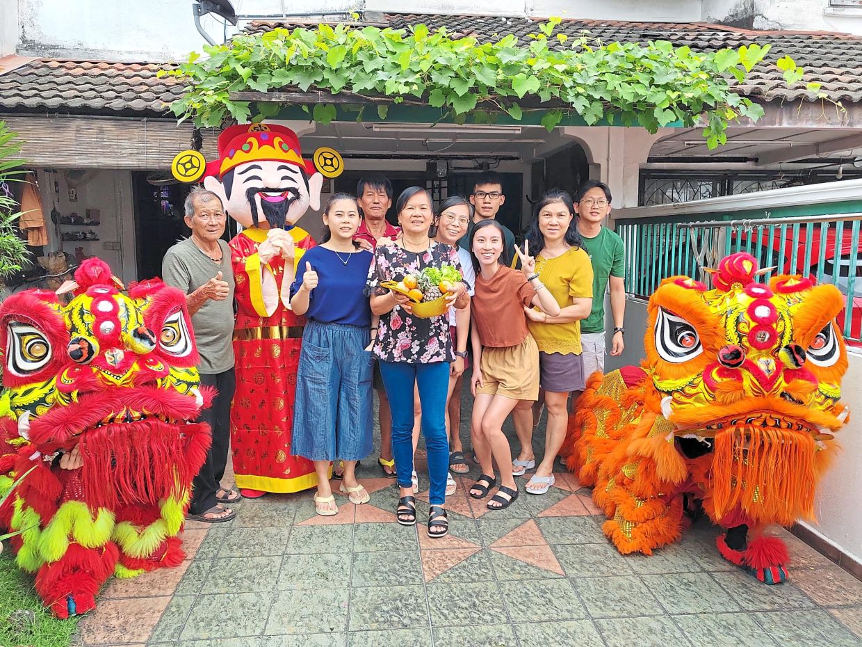 Competition winner Tan Nyom Khim (third from left) and her family posing for a photo after receiving a hamper, mandarin oranges and the gift of a lion dance performance from Mydin, presented by Mydin Subang Jaya branch manager Azlina Mat Kassim in Petaling Jaya, Selangor on Jan 31.