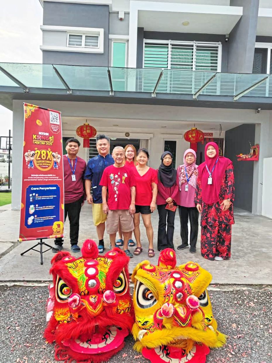 Competition winner Lee Chee Leong and his family (centre) celebrating his win of a free lion dance performance at his home together with Mydin Kajang branch managers and their team in Kajang,Selangor on Feb 2.