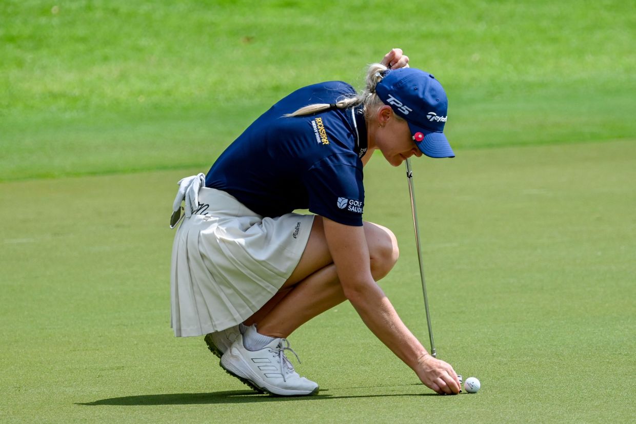 Charley Hull of England marks her ball on the green during round three of HSBC Women's Championship golf tournament at Sentosa Golf Club in Singapore on Saturday, March 1, 2025. --Photo by Roslan RAHMAN / AFP