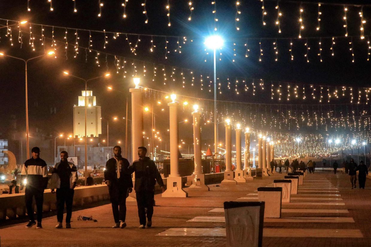 People walk along the decorated seaside corniche, on the first day of the Muslim holy fasting month of Ramadan, in Libya's second-largest city of Benghazi early on Saturday, March 1, 2025. -- Photo by Abdullah DOMA / AFP