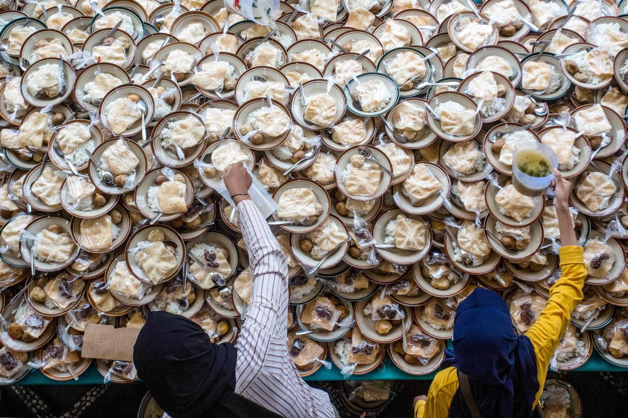 Muslims receive free iftar meals to break their fast during the Islamic holy fasting month of Ramadan at the Jogokariyan Mosque in Yogyakarta on Sunday, March 2, 2025. -- Photo by DEVI RAHMAN / AFP
