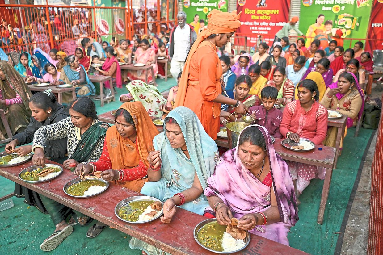 Hindu pilgrims having their meal at a community kitchen during the Maha Kumbh Mela in Prayagraj. — AFP