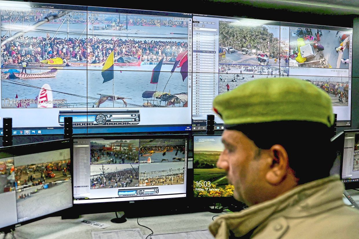 A policeman monitoring the crowd during the Maha Kumbh Mela via screens set up at the Integrated Command and Control Centre in Prayagraj. - AFP