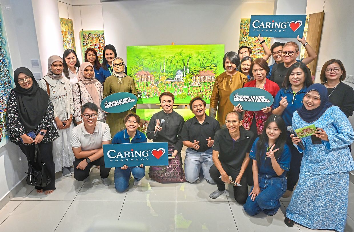 Flanking the painting turned into Hari Raya packets are Noor Sa’adah (left) and Wan Jamila, with Wong to the artist’s left, alongside Caring Pharmacy and Artjamila Gallery and Museum staff in Shah Alam. — Photos: RAJA FAISAL HISHAN/The Star