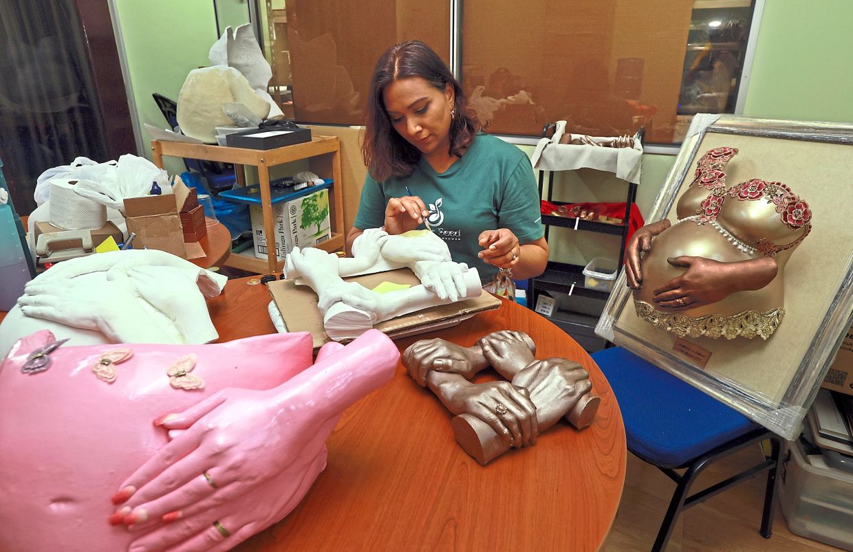 Vatsala making pregnant belly casts, where she applies wet plaster gauze over the abdomen and removes the cast once it dries.