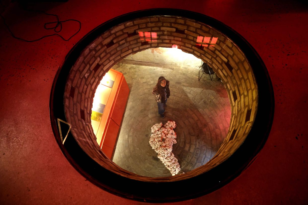 A woman stands in front of a sculpture, part of a multimedia exhibition by Iranian artist Mimi Amini at the Argo Factory. Photo: AFP 