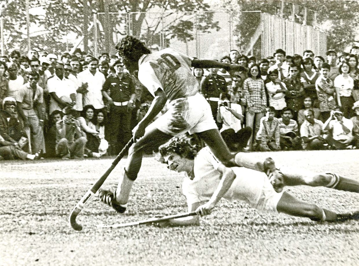Hockey hero: M. Mahendran dribbling past a Dutch defender who slipped in his attempt to stop the Malaysian player. — THAM CHOON FATT/The Star