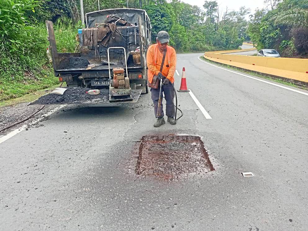 Patch job: The edges of a pothole is neatened and the depths filled in before a literal patch is placed on the surface. When you have many potholes, though, this is a temporary measure – the road should actually be resealed instead. — Photos provided